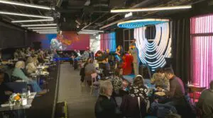 People eating and drinking during Sunday Jazz Brunch while two musicians perform on stage